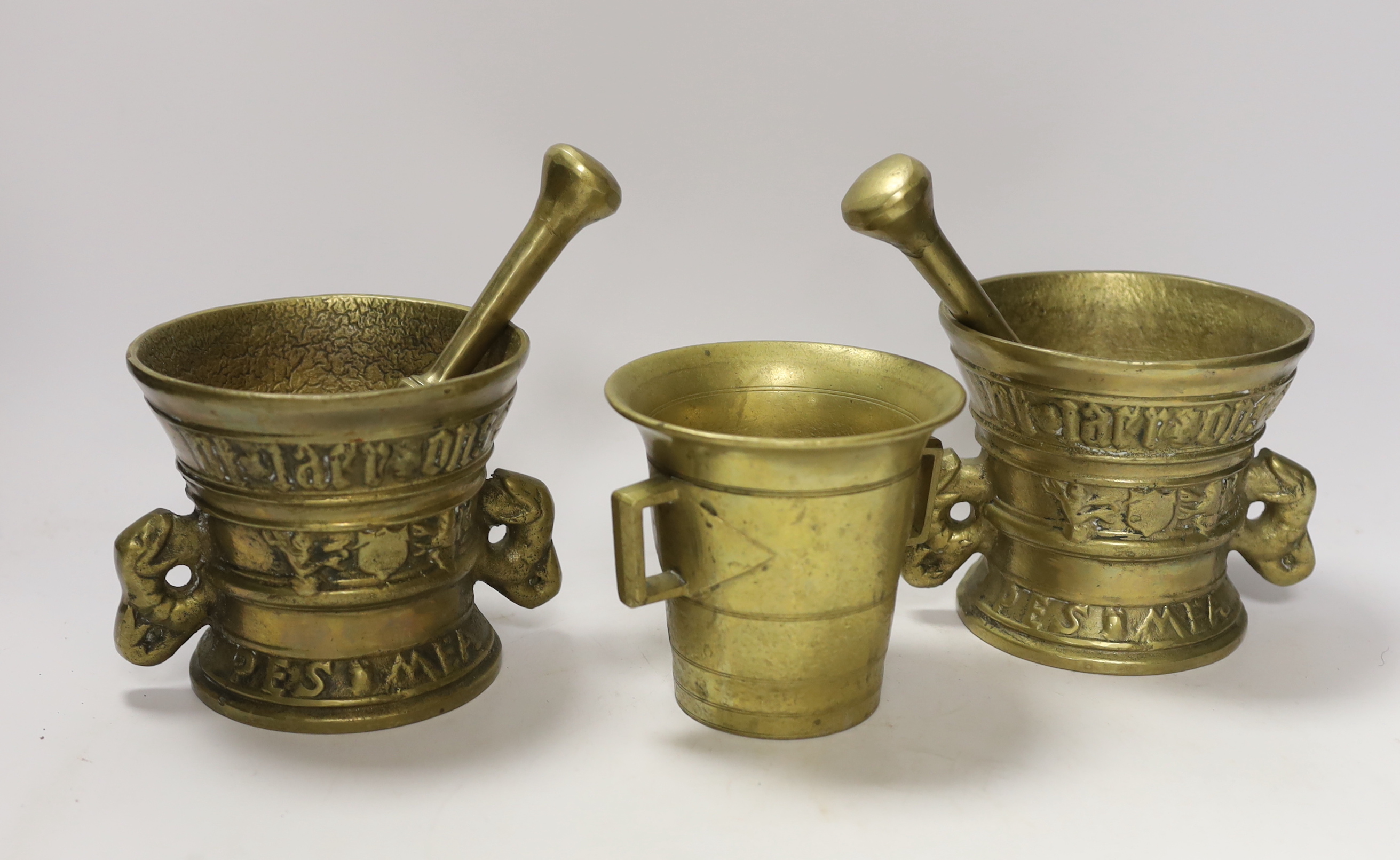 Three bronze / brass mortars and two pestles and a medallion